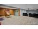 Finished basement with entertainment area, vinyl flooring and a glass sliding door at 12923 Plumleaf Dr, Charlotte, NC 28213