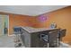 Finished basement bar area with a dark wood counter and black leather stools at 12923 Plumleaf Dr, Charlotte, NC 28213