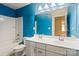 Bathroom with blue walls featuring a double sink vanity and a shower/tub combo at 12923 Plumleaf Dr, Charlotte, NC 28213
