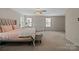 A bedroom with a large carpet area and a ceiling fan, offering plenty of light at 12923 Plumleaf Dr, Charlotte, NC 28213