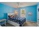 Bright blue bedroom featuring a bed with unicorn-themed sheets and a large window at 12923 Plumleaf Dr, Charlotte, NC 28213