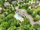 Aerial view features a pool area, surrounded by lush greenery and mature trees, creating a serene and inviting ambiance at 12923 Plumleaf Dr, Charlotte, NC 28213