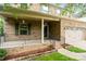 Inviting covered front porch with brick foundation, black railings, and a welcoming entryway at 12923 Plumleaf Dr, Charlotte, NC 28213