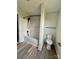 A bathroom featuring a tub and shower with black hardware and fixtures, a toilet, and vinyl flooring at 1308 Austin Chaney Rd, Wingate, NC 28174