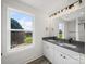 Bright bathroom featuring granite countertops, dual sinks, modern vanity, and a scenic outdoor view at 1308 Austin Chaney Rd, Wingate, NC 28174