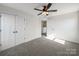 Sunlit bedroom featuring a ceiling fan, closet, and plush carpeting, offering a serene and comfortable space at 1308 Austin Chaney Rd, Wingate, NC 28174