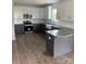 A modern kitchen features white cabinets, granite countertops, stainless steel appliances, and an apron-front sink at 1308 Austin Chaney Rd, Wingate, NC 28174