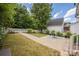 This backyard has a brick patio, green grass, and a white fence at 14105 Garden District Row, Huntersville, NC 28078