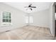 The vacant bedroom has three bright windows and neutral carpet at 14105 Garden District Row, Huntersville, NC 28078