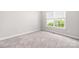 This bedroom is carpeted, with neutral walls and a window for natural light at 14105 Garden District Row, Huntersville, NC 28078