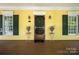Welcoming front porch with a charming screen door and decorative floral arrangements on small tables at 14105 Garden District Row, Huntersville, NC 28078