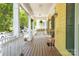 Cozy front porch with views, showcasing decorative plants and a swing for relaxing outdoor living at 14105 Garden District Row, Huntersville, NC 28078