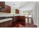 Bright kitchen featuring dark wood cabinetry, modern appliances, and seamlessly connecting to a dining area at 14105 Garden District Row, Huntersville, NC 28078