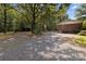 Gravel driveway leading to a charming brick home surrounded by a lush, green forest at 14415 Old Beatty Ford Rd, Gold Hill, NC 28071