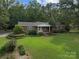 Charming brick home with a well-maintained front lawn and mature trees at 14415 Old Beatty Ford Rd, Gold Hill, NC 28071