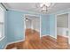 Open-concept room with hardwood floors and natural light, connecting to another living space at 14415 Old Beatty Ford Rd, Gold Hill, NC 28071