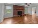 Living room with a brick fireplace, hardwood floors, and natural light from the windows at 14415 Old Beatty Ford Rd, Gold Hill, NC 28071