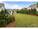 View of a lush backyard with a well-maintained lawn and neatly trimmed hedges at 16034 Rushwick Dr, Huntersville, NC 28078