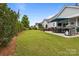 Expansive backyard featuring a covered patio, lush lawn, and manicured landscaping at 16034 Rushwick Dr, Huntersville, NC 28078