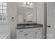 Bright bathroom featuring a vanity with granite countertops, white cabinets, and a large mirror at 16034 Rushwick Dr, Huntersville, NC 28078