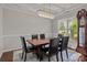Formal dining room with a modern chandelier, dark wood table, and six leather chairs at 16034 Rushwick Dr, Huntersville, NC 28078