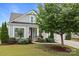 Inviting front exterior with manicured landscaping, covered entry, and attached two-car garage at 16034 Rushwick Dr, Huntersville, NC 28078