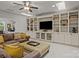 Inviting living room featuring custom built-ins, a ceiling fan, and plush seating at 16034 Rushwick Dr, Huntersville, NC 28078