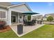 Covered outdoor patio with barbecue and dining area, perfect for entertaining guests at 16034 Rushwick Dr, Huntersville, NC 28078