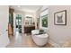Bright bathroom featuring a soaking tub, granite vanity, and a glimpse into the Primary bedroom at 164 Twin Sisters Ln, Mooresville, NC 28117