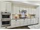 Modern kitchen with stainless steel appliances, white cabinets, and granite countertops at 164 Twin Sisters Ln, Mooresville, NC 28117