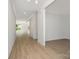 Spacious hallway with wood-look floors and white trim, leading to other rooms with natural light at 1807 Country Club Rd, Lincolnton, NC 28092