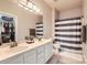 Bathroom featuring double sinks, striped shower curtain, and walk-in closet with ample storage at 18605 Ruffner Dr # 3E, Cornelius, NC 28031