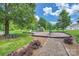 Community playground surrounded by trees, with benches and a picnic table at 18605 Ruffner Dr # 3E, Cornelius, NC 28031