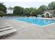 Large community pool with plenty of lounge chairs and a building with a covered area for relaxing near the water at 18605 Ruffner Dr # 3E, Cornelius, NC 28031
