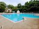 Inviting community pool with ample lounge seating surrounded by lush greenery, perfect for relaxation and recreation at 18605 Ruffner Dr # 3E, Cornelius, NC 28031