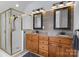 Modern bathroom with a glass-enclosed shower, double vanity with granite countertop, and wood-look wall decor at 20324 Middletown Rd, Cornelius, NC 28031