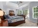 Spacious bedroom with bay windows, a large bed with quilt and decorative furniture at 20324 Middletown Rd, Cornelius, NC 28031