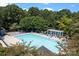 Community pool with lounge chairs, umbrellas, and a pergola for relaxing by the sparkling blue water at 20324 Middletown Rd, Cornelius, NC 28031
