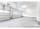 A spacious three car garage with windows, concrete floors, and bright white walls provides ample parking and storage space at 236 Wheatfield Dr # 102P, Statesville, NC 28677