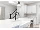 Island sink with a view of staircase, white cabinets with marble backsplash, and stainless steel appliances at 236 Wheatfield Dr # 102P, Statesville, NC 28677