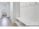 Mudroom with shiplap, bench seating, coat hooks, and access to a powder room at 236 Wheatfield Dr # 102P, Statesville, NC 28677