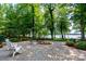 Beautiful backyard patio with lush landscaping and tranquil lake view in the distance at 258 Patterson'S Bridge None, New London, NC 28127