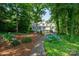 Landscaped front yard featuring a well-maintained lawn, mature trees, and a brick walkway leading to the home at 258 Patterson'S Bridge None, New London, NC 28127
