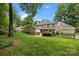 Landscaped backyard featuring a lush lawn, mature trees, and a charming fence at 2709 Wamath Dr, Charlotte, NC 28210