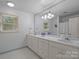 Bright bathroom features double sinks, large mirror, and neutral tile flooring at 2709 Wamath Dr, Charlotte, NC 28210