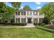Elegant, two-story home with a classic painted brick facade, black shutters, and professionally landscaped front yard at 2709 Wamath Dr, Charlotte, NC 28210