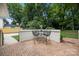 Back patio offers an outdoor dining area, basketball hoop, and lush greenery at 2709 Wamath Dr, Charlotte, NC 28210