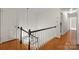 Upstairs staircase featuring hardwood floors, white railings, and decorative lighting fixture at 2709 Wamath Dr, Charlotte, NC 28210