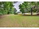 Spacious backyard features lush green grass, mature trees, and outbuildings at 2921 Ambrose Dr, Gastonia, NC 28056