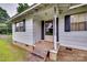 Close-up of the front porch featuring a white painted exterior, black shutters and a storm door entrance at 2921 Ambrose Dr, Gastonia, NC 28056